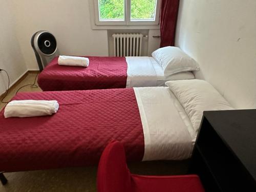 two beds with red and white sheets in a room at Venice Best Vacation in Marghera
