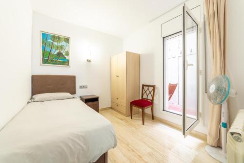 1 dormitorio con 1 cama y ventana con ventilador en Mar & Cunit, en Cunit