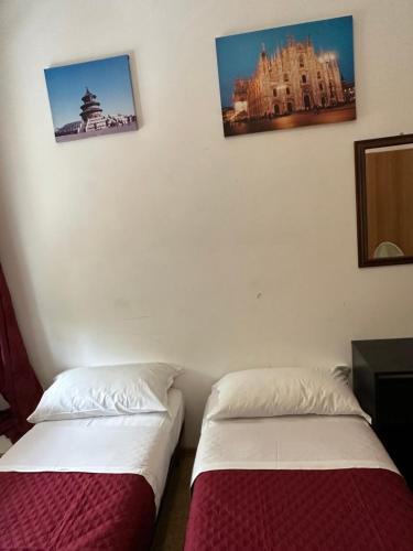 two beds in a room with two pictures on the wall at Venice Best Vacation in Marghera