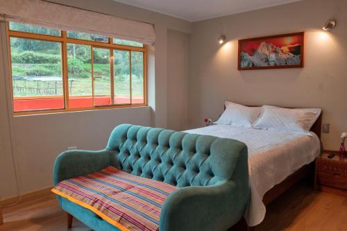 a bedroom with a bed and a blue couch at Casa Alojamiento Tocllaraju in Tarica