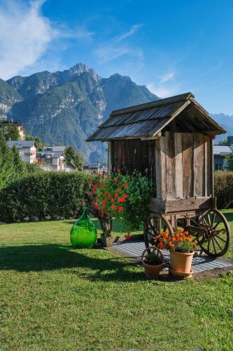 a wooden cart with flowers in a yard at B&B Il Tabià in Pieve di Cadore