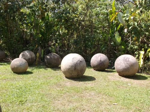 a group of stone spheres sitting on the grass at Hotel Veragua River House in Sierpe