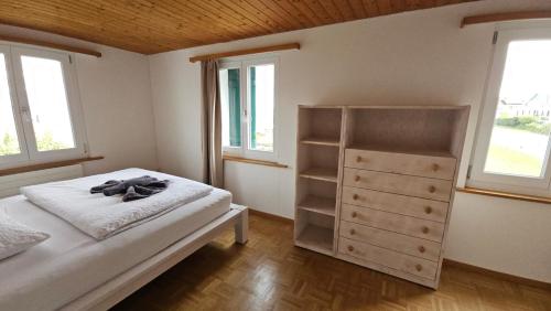 a bedroom with a bed and a dresser and two windows at MBar Apartment in Altnau
