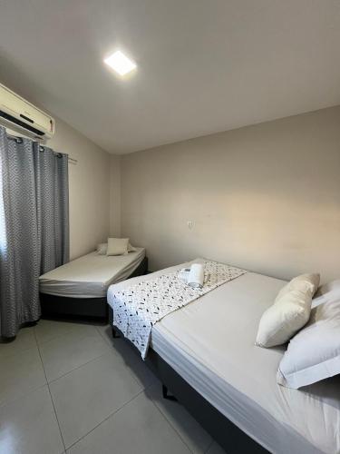 a room with two beds and a window at Casa Lua in Brumadinho