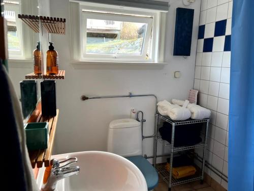 baño con lavabo y aseo y ventana en Small Seaside Cottage, en Saltsjöbaden