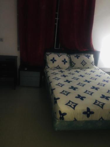 a bed with blue and white sheets and pillows at Mr Gabriel apartment in Accra