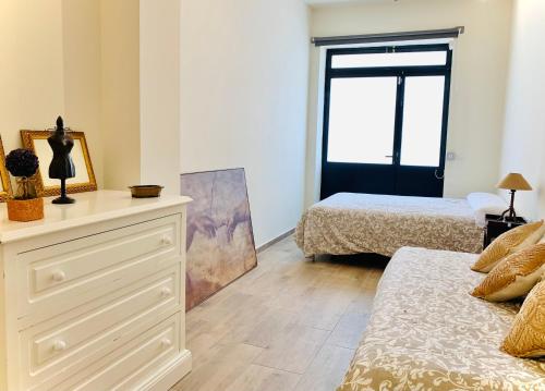 1 dormitorio con 2 camas y vestidor con espejo en Un espacio diferente en Triana., en Sevilla