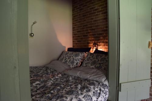 Bett in einem Zimmer mit Ziegelwand in der Unterkunft It Foarhús in Eernewoude