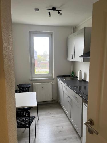 a kitchen with white cabinets and a table and a window at Monteur-Pension N2 in Siemitz
