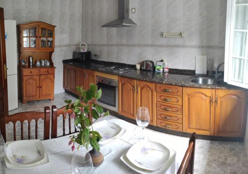 una cocina con mesa, mantel blanco y sidx sidx sidx de mesa en Casa Mari&Fernando en Camelle - Costa da Morte en Camelle