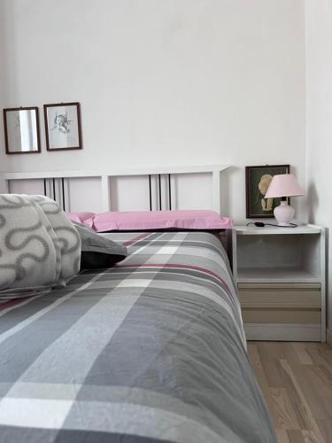 een slaapkamer met een bed en een tafel met een lamp bij A due passi dal lago in Canzo