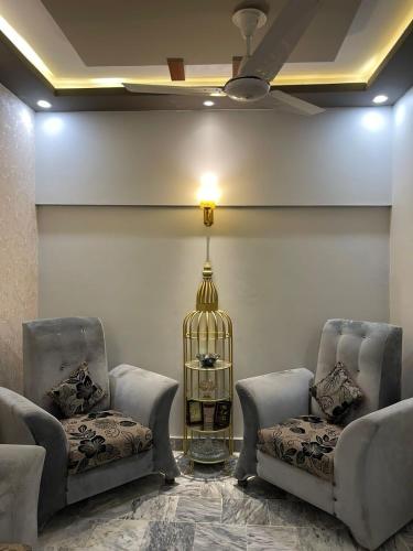a waiting room with two chairs and a bird cage at Cozy 2-Bed Portion at Gulshan Iqbal blk 7 in Karachi