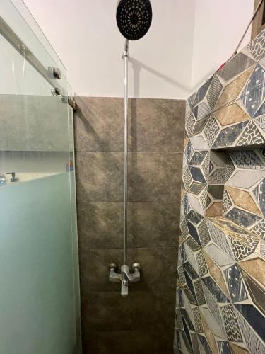 a shower in a bathroom with a tile wall at Cozy 2-Bed Portion at Gulshan Iqbal blk 7 in Karachi