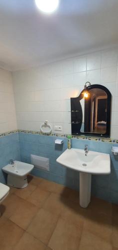 een badkamer met een wastafel, een toilet en een spiegel bij Kabila vista n4 vue piscine in M'diq