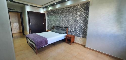 a bedroom with a bed and a wall at Kabila vista n4 vue piscine in M'diq
