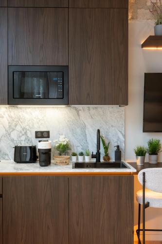 une cuisine avec un évier et un micro-ondes dans l'établissement SAINT- PAUL - LUXURY APARTMENT IN HOTEL DE VILLE, à Paris