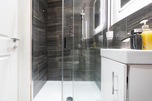 a shower with a glass door next to a sink at New Build 4 bed Det House in Yorkshire Nr Leeds in Batley