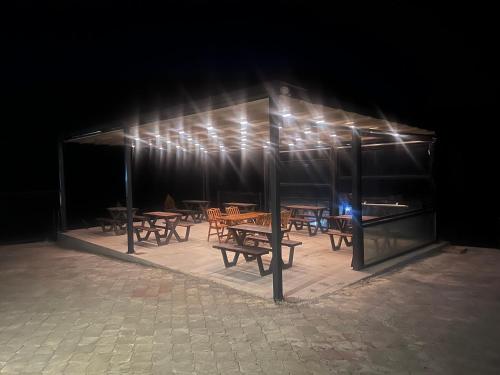 a group of tables and chairs in a pavilion at night at Mavrovo Square " Villas & Apartment " in Mavrovo