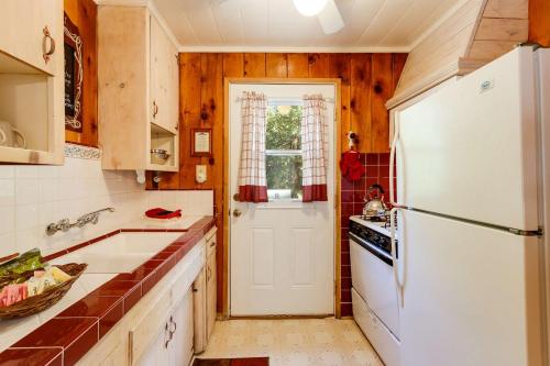 a kitchen with a white refrigerator and a sink at Arrowhead Pine Rose Cabins in Twin Peaks