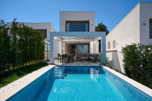 a swimming pool in front of a house at Villa Paradisio 2, Pool, Sea View in Hanioti