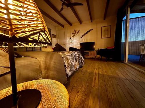 a living room with a bed and a couch at Bungalow L'hibiscus in Sainte-Luce