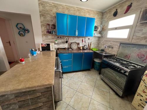 una cucina con armadi blu e piano cottura di Golden beach 2 Ras sedr Cozy chalet a Ras Sedr