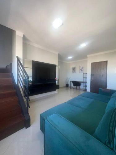 un soggiorno con divano e TV a schermo piatto di Exclusiva Cobertura Duplex a Patos de Minas