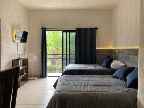 a bedroom with two beds and a sliding glass door at Excelente Loft Céntrico in Zinapécuaro de Figueroa
