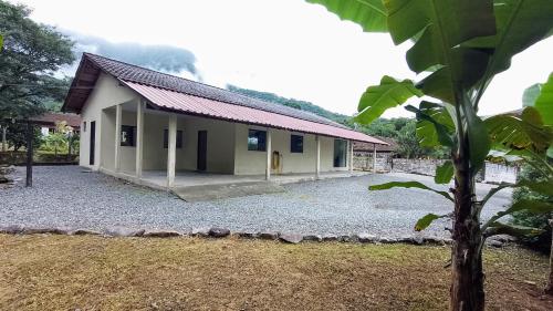ein Haus mit einem Kieshof davor in der Unterkunft Fazendinha Mildau in Joinville