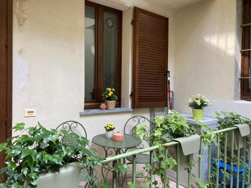 a balcony with a table and plants and a door at La casetta in Cuneo