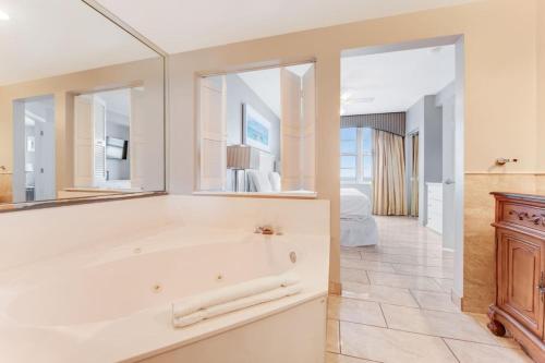 een badkamer met een bad en een grote spiegel bij Oceanfront Bliss 3BR Direct Ocean Front Retreat on the 4th Floor at The WyndhamOcean Walk Resort in Daytona Beach
