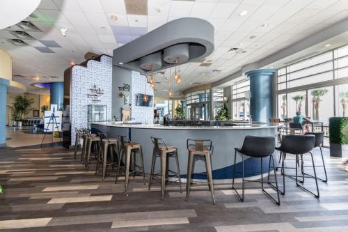 a bar in a restaurant with stools at 10th Floor Oasis Stunning 2BR with Spacious Private Double Balcony at The Wyndahm Ocean Walk Resort in Daytona Beach