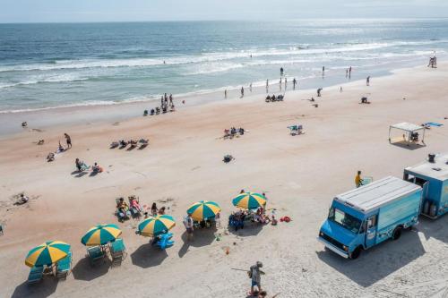 an overhead view of a beach with umbrellas and a food truck at 10th Floor Oasis Stunning 2BR with Spacious Private Double Balcony at The Wyndahm Ocean Walk Resort in Daytona Beach