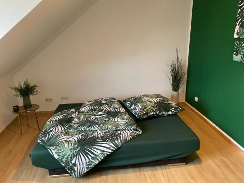 a green bed with two pillows in a room at Bambus, Jungle, Dachterrasse & bequem bis Zentrum in Radebeul