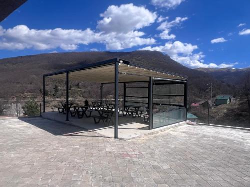 a pavilion with benches and a view of a mountain at Mavrovo Square " Villas & Apartment " in Mavrovo