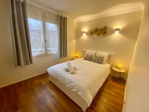 um quarto com uma cama branca e uma janela em Maisons Alfort - Cosy appartement em Maisons-Alfort