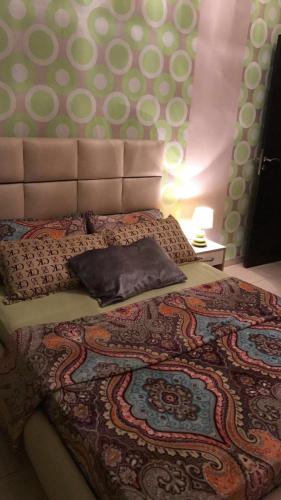 een slaapkamer met een groot bed met een hoofdeinde bij Appartement neuf avec piscine in Zemmour Touirza