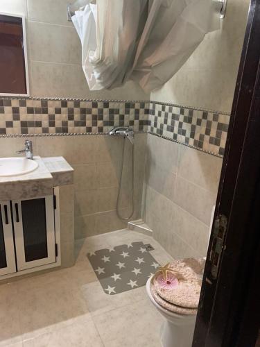 een badkamer met een douche, een toilet en een wastafel bij Appartement neuf avec piscine in Zemmour Touirza