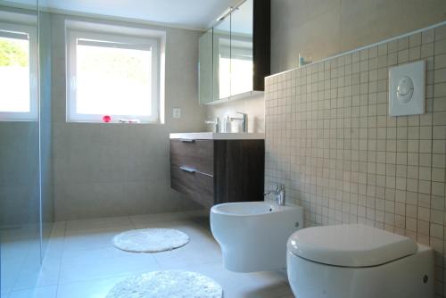 a bathroom with a toilet and a sink and a window at Spacious apartment in Sarpsborg