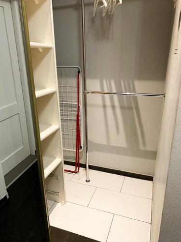 uma cabina de duche ao nível do chão com uma mangueira vermelha no armário em Turzyn Apartament: Idealne miejsce na Twój wypoczynek em Szczecin