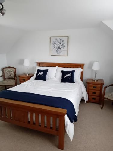 a bedroom with a large bed with blue and white pillows at Ocean View in Bushmills