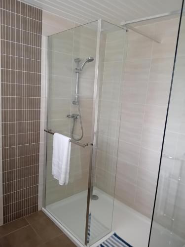 a glass shower stall with a white towel at Ocean View in Bushmills