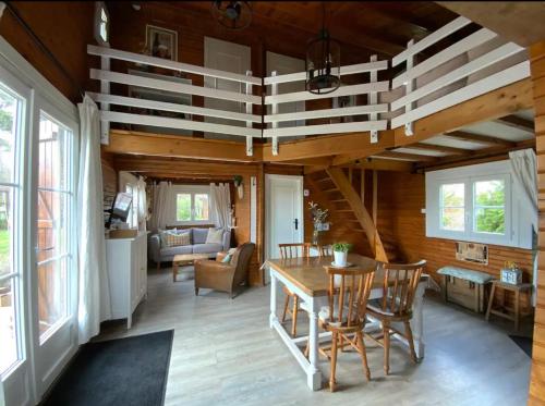 une salle à manger avec une table et des chaises dans une maison dans l'établissement Chalet à 50m de la mer - Gold Beach Cottage, à Ver-sur-Mer