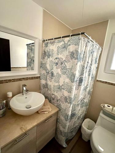 a bathroom with a sink and a shower curtain at Agradable estancia en Monterrico in Monterrico