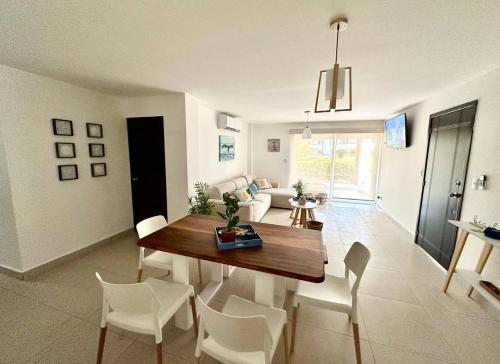 a dining room and living room with a table and chairs at Agradable estancia en Monterrico in Monterrico