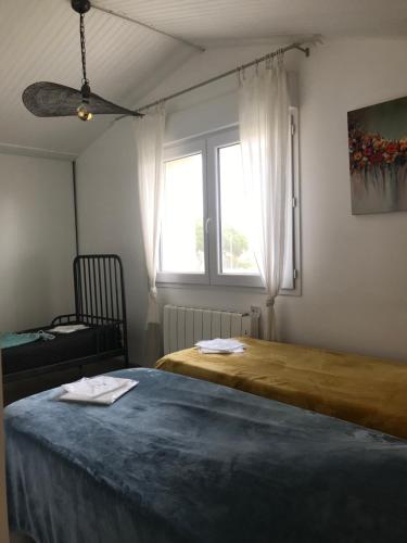 une chambre avec deux lits et une fenêtre dans l'établissement Maison centre du village, à Grand-Village-Plage