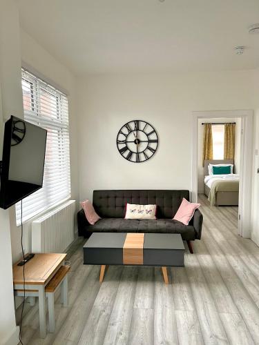 un soggiorno con divano e orologio sul muro di Luton flat with parking a Luton