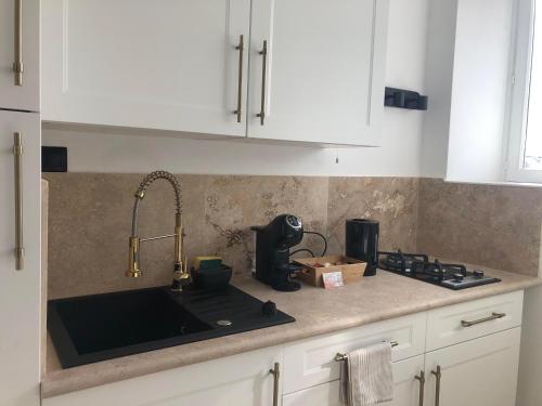 a kitchen counter with a sink and a stove at Appartement cœur de ville décoré en pierre naturelle in Chinon