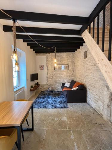 a living room with a couch and a brick wall at La maison de pierres in Chablis