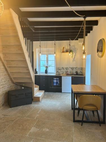 - une cuisine et une salle à manger avec une table et des escaliers dans l'établissement La maison de pierres, à Chablis